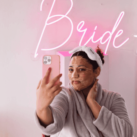 Image of a bride taking a selfie wearing the SKOON BFF Mask